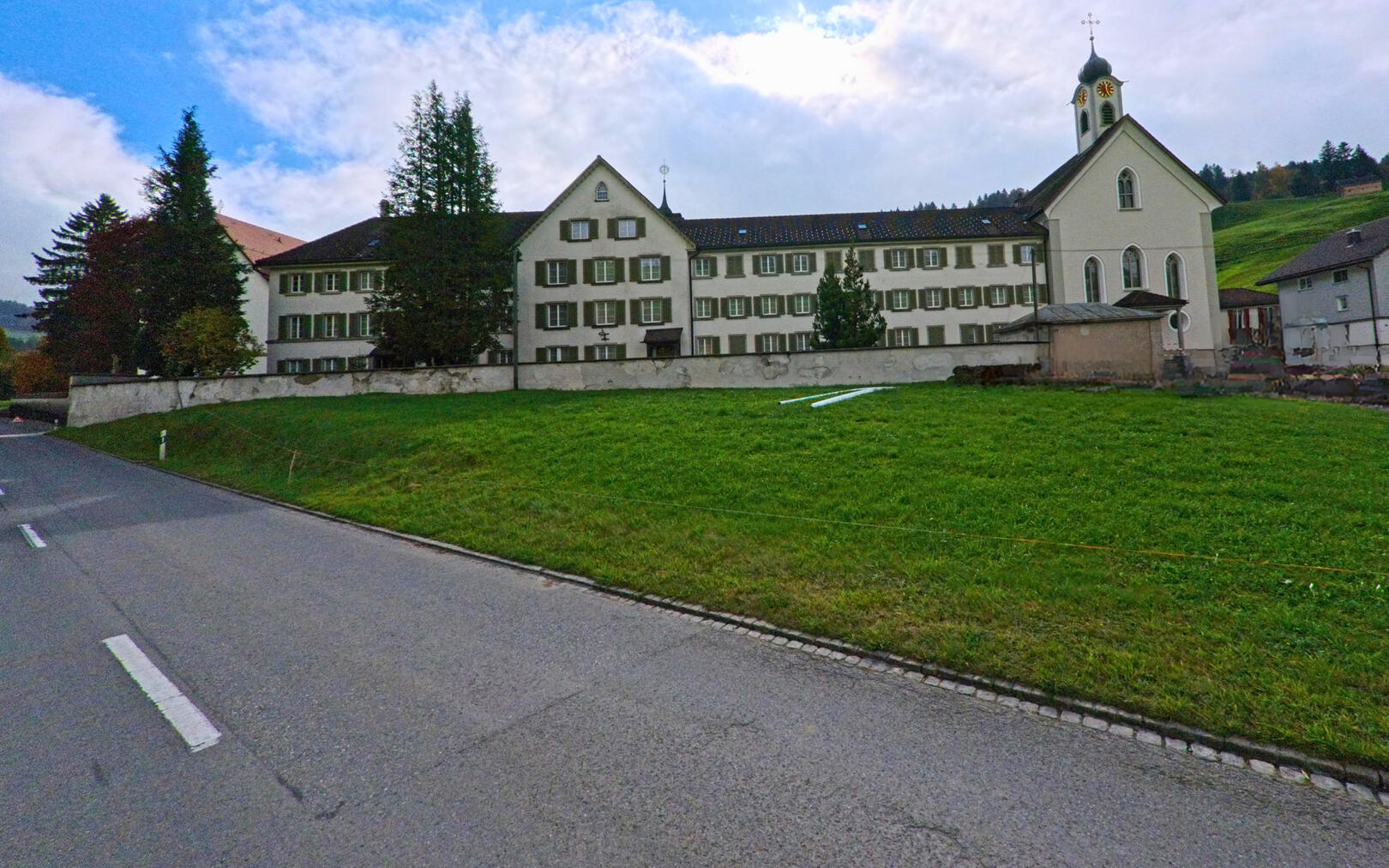 In Gonten (9108, Kanton Appenzell Innerrhoden) ist das imposante Gebäude mit der angeschlossenen Kirche gut sichtbar, umgeben von einer grünen Wiese und einer