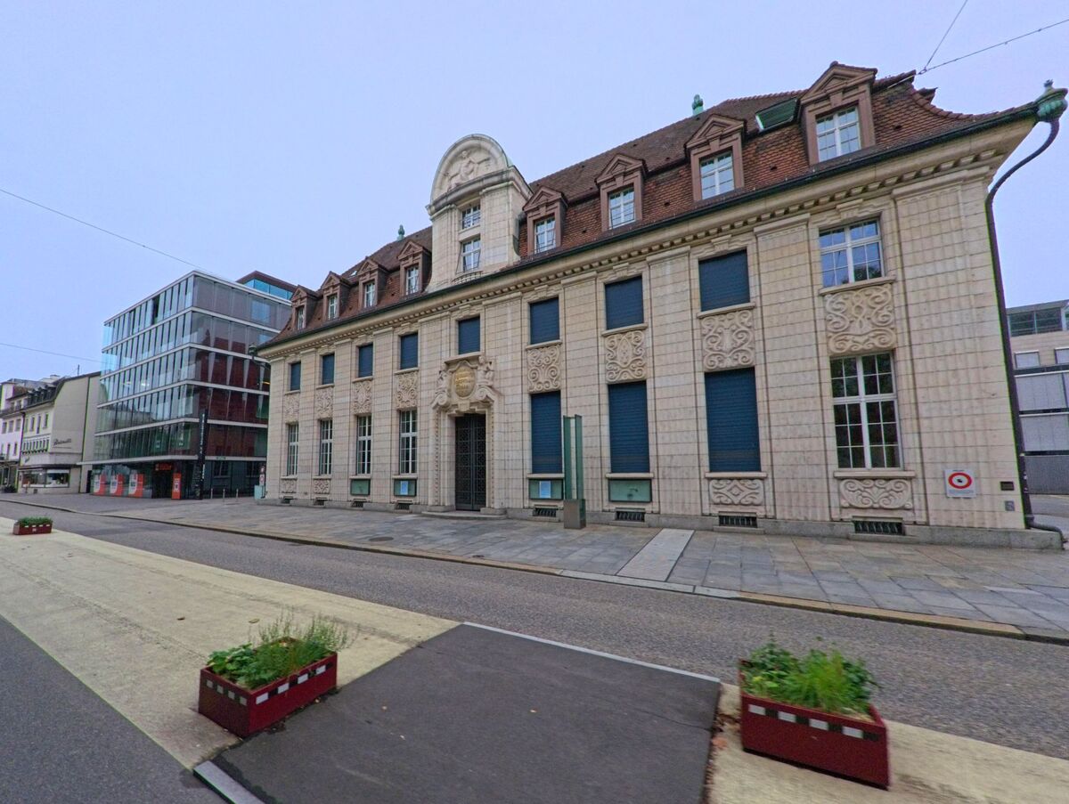 In Aarau (5000, Kanton Aargau) steht ein historisches Gebäude mit reich verzierter Fassade neben modernen Glasbauten an einer breiten Strasse..jpg