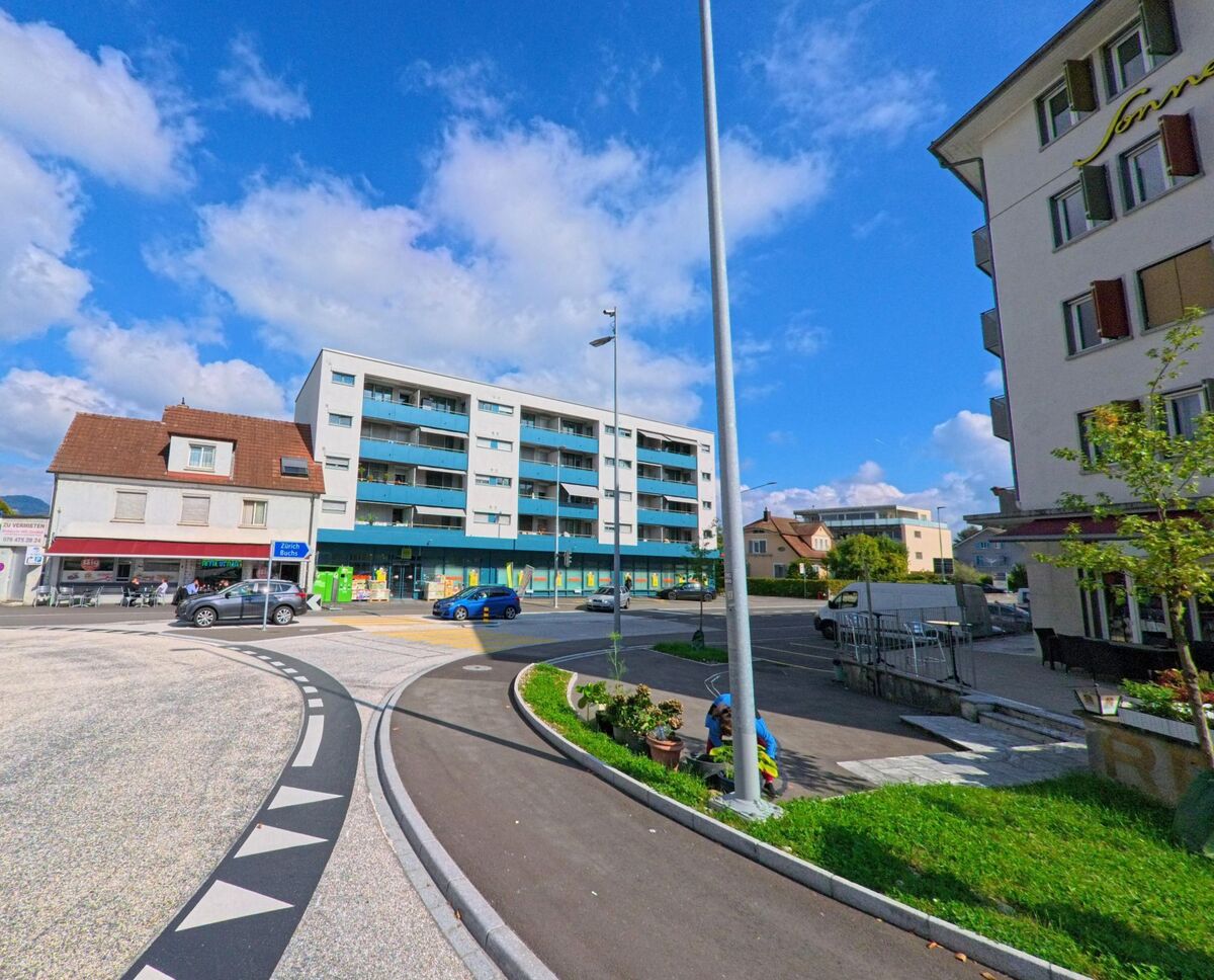 Ein moderner Kreisverkehr in Aarau (5001, Kanton Aargau) verbindet mehrere Strassen, umgeben von Wohn- und Geschäftsgebäuden unter einem klaren blauen Himmel.