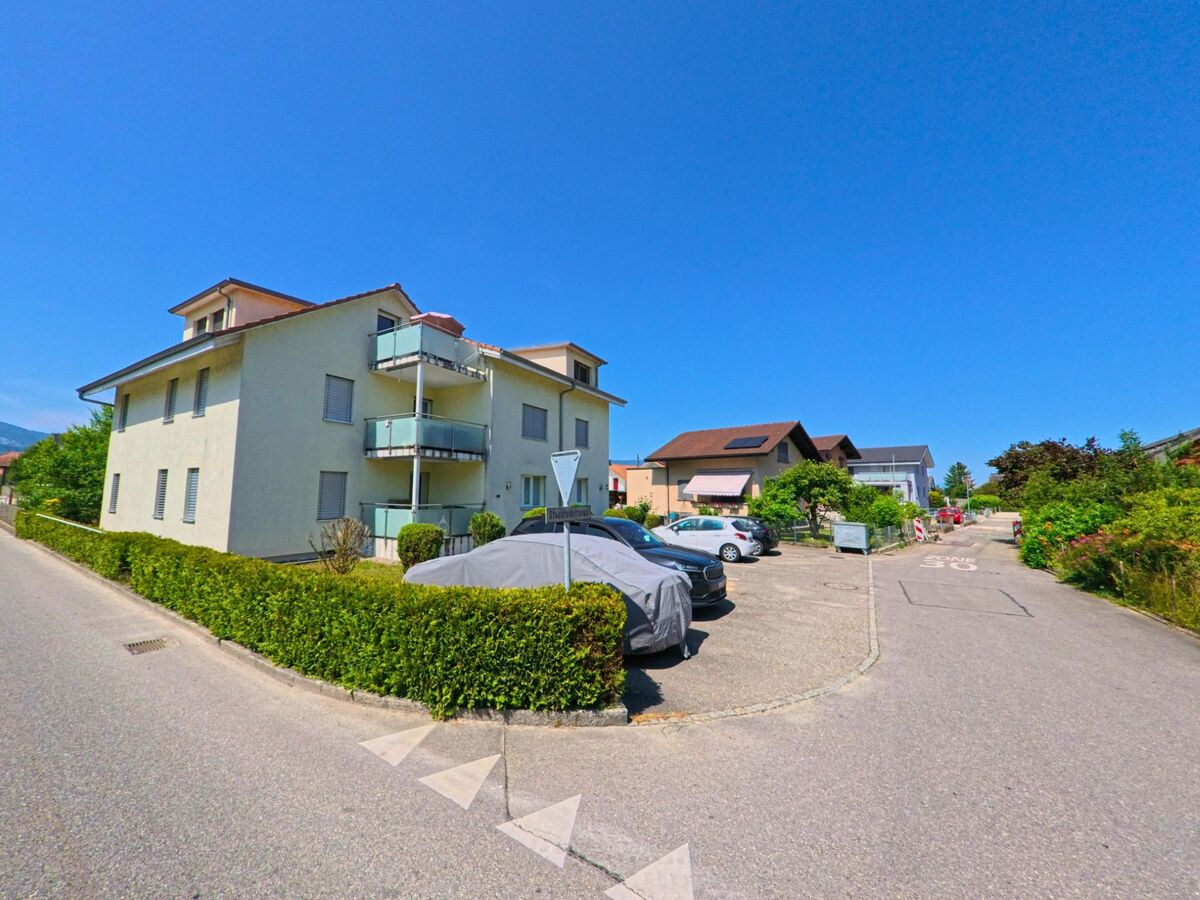 In einem ruhigen Wohnquartier von Aegerten (2558, Kanton Bern) steht ein modernes Mehrfamilienhaus mit Balkonen und angrenzendem Parkplatz an der Rebenwegstrasse.