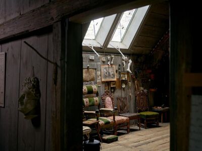 Im Albert Anker Haus in Ins (3232, Kanton Bern) zeigt ein Dachraum historische Moebel, Bilder und Kunstobjekte im warmen Tageslicht.