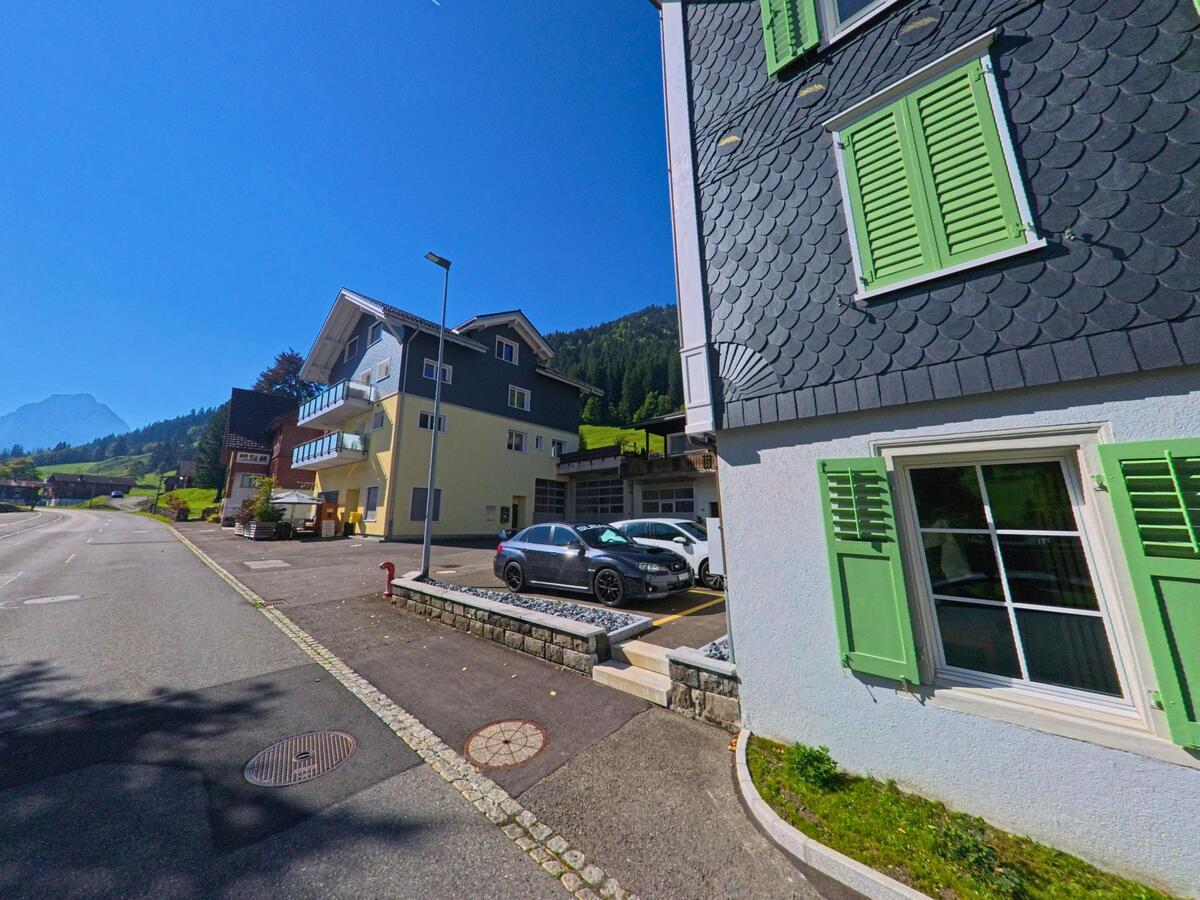 Mehrere Wohnhäuser gruppieren sich entlang einer schmalen Strasse in Alpthal (8849, Kanton Schwyz).