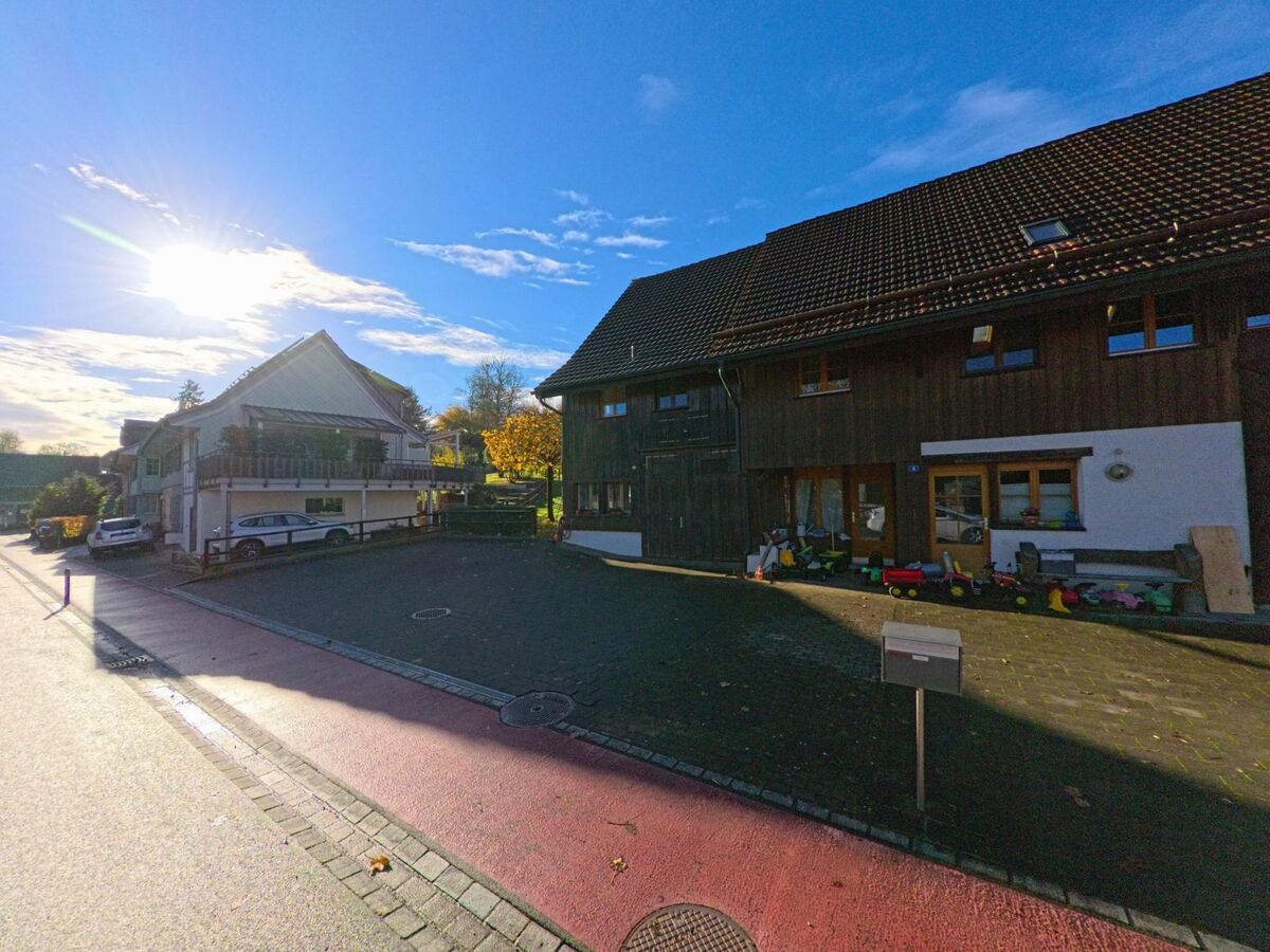 Zwischen landwirtschaftlichen Gebaeuden und einem ruhigen Hof zeigt sich eine sonnige Wohnsituation in Amlikon-Bissegg (8514, Kanton Thurgau) am spaeten Nachmittag.