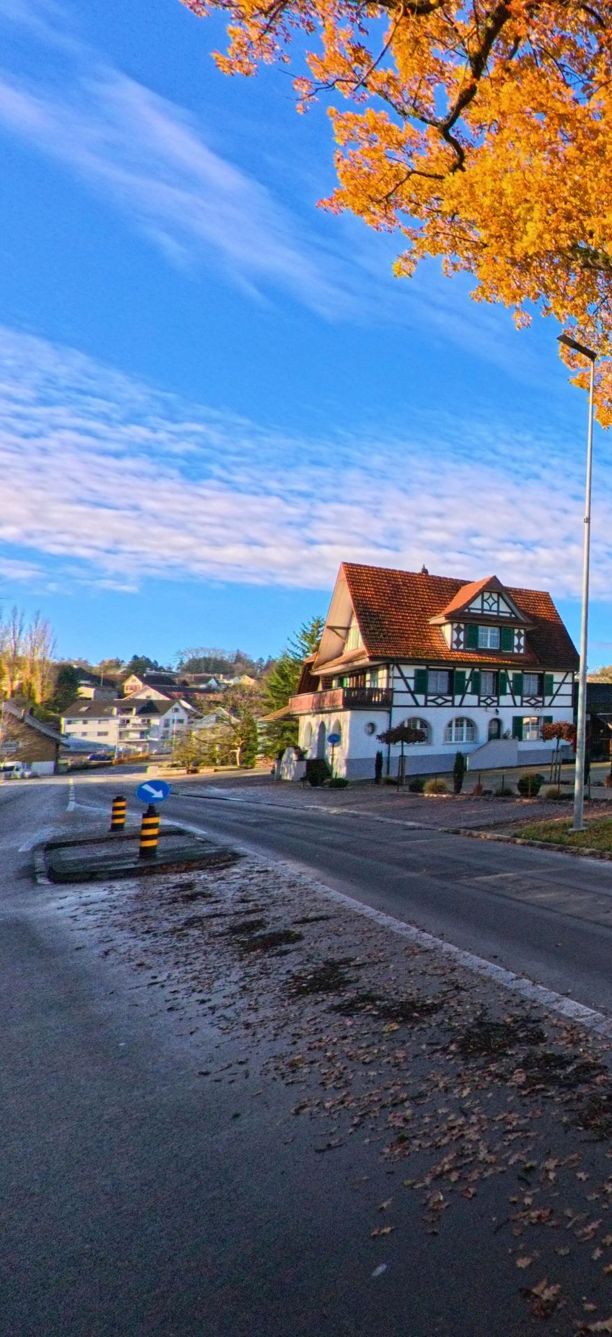 An einer Kreuzung mit Fachwerkhaus und herbstlich gefaerbten Baeumen praegt das Ortsbild von Amlikon-Bissegg (8514, Kanton Thurgau) die ruhige Dorflage.