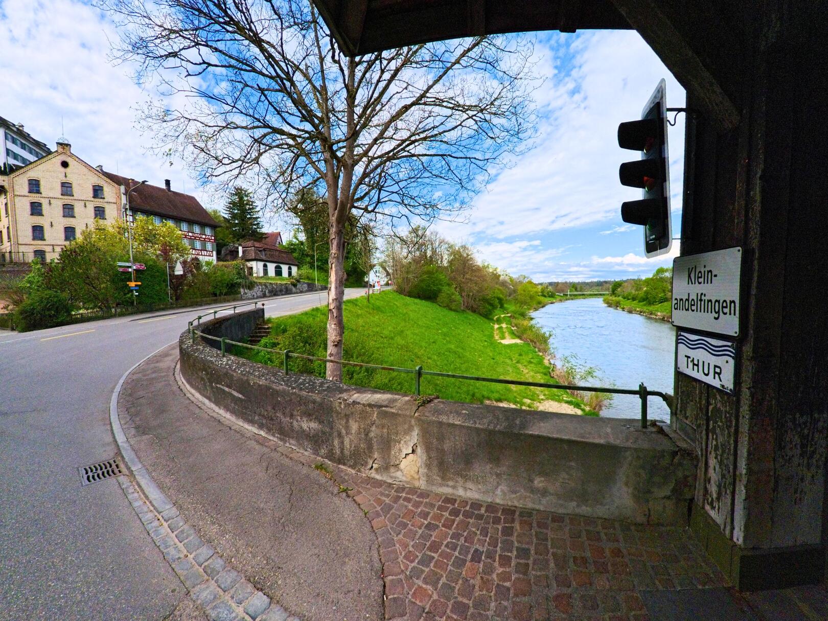 Von einer gedeckten Holzbrücke in Andelfingen (8453, Kanton Zürich) blickt man auf die Thur und den gegenüberliegenden Ortsteil Kleinandelfingen.