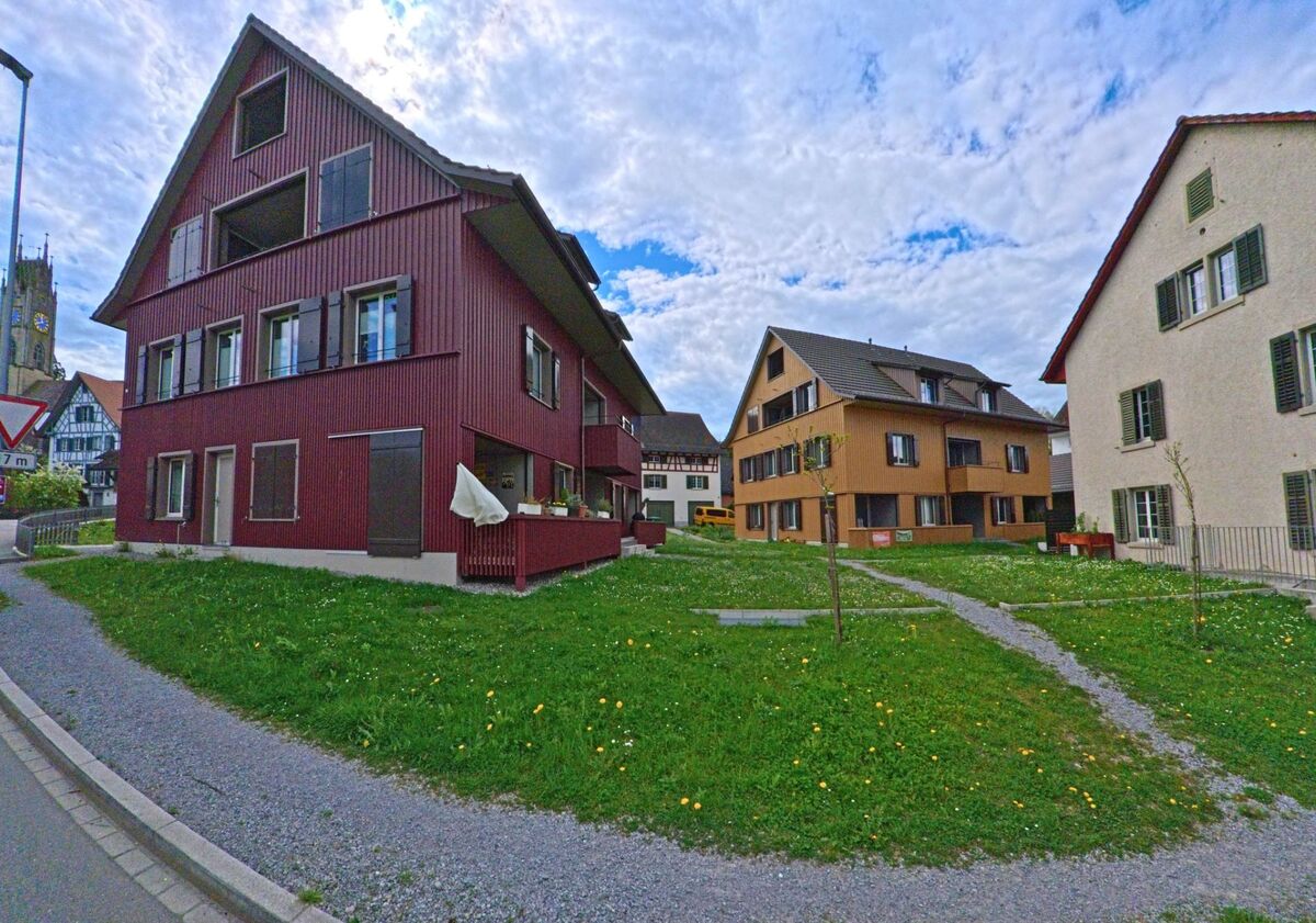 In Andelfingen (8453, Kanton Zürich) stehen moderne Holzhäuser mit Gartenflächen in einem ruhigen Wohnquartier nahe dem Kirchturm.