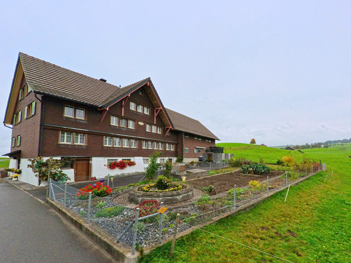 Ein traditionelles Bauernhaus mit eingezäuntem Garten befindet sich am Dorfrand von Andwil (9212, Kanton St. Gallen).