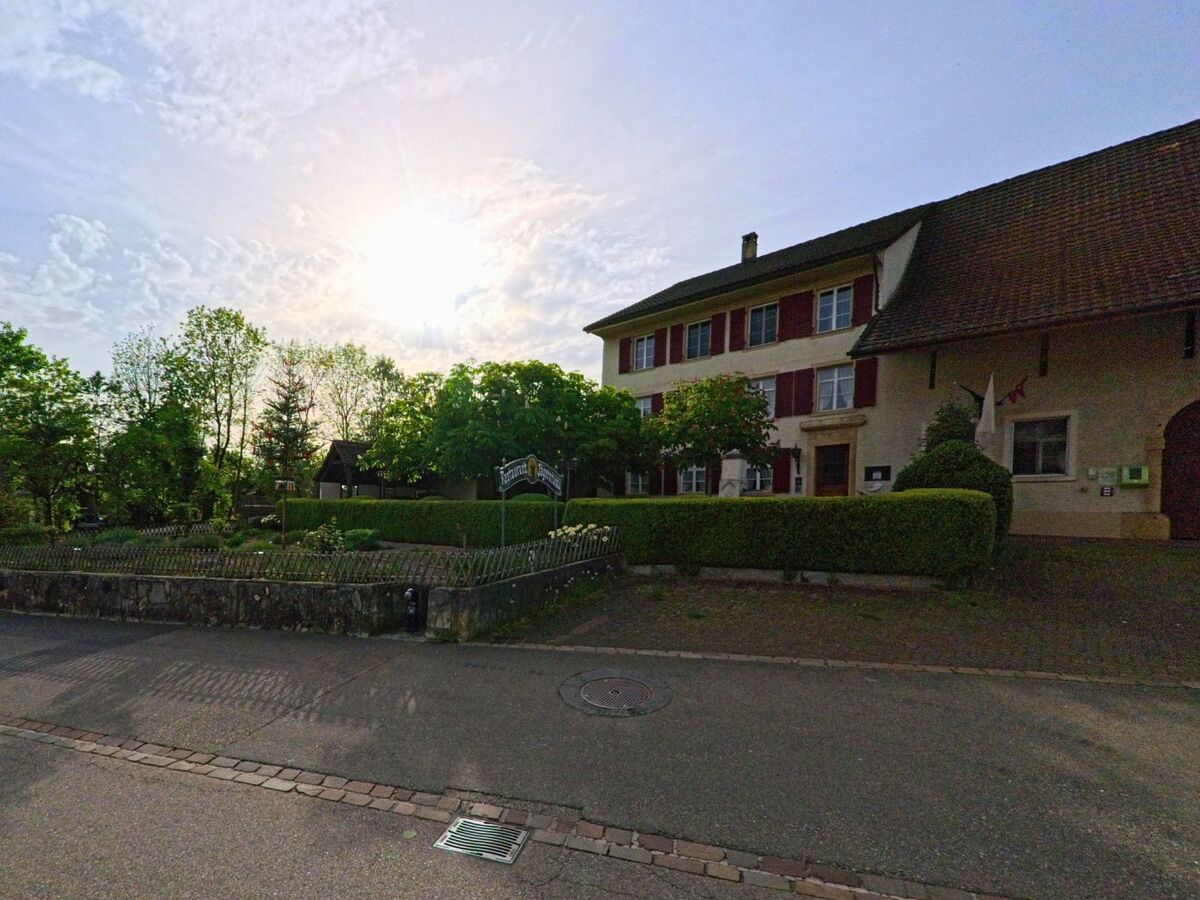 In Anwil (4469, Kanton Basel-Landschaft) steht ein historisches Gebäude mit roten Fensterläden neben einem gepflegten Garten und dem Restaurant Rössli.