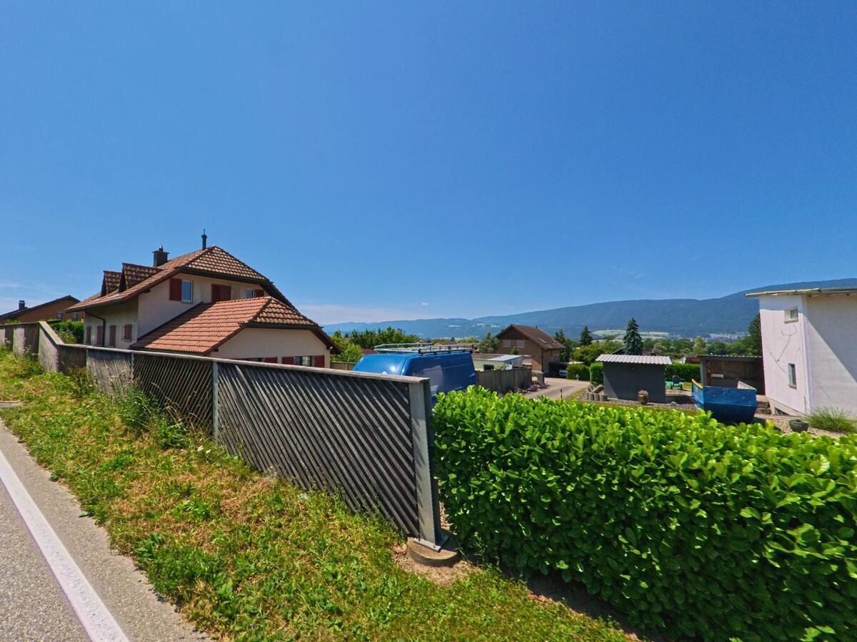 Am südlichen Rand von Arch (PLZ 3296, Kanton Bern) bieten Wohnhäuser mit roten Ziegeldächern einen weiten Ausblick auf die umliegende Landschaft und Hügelzüge.