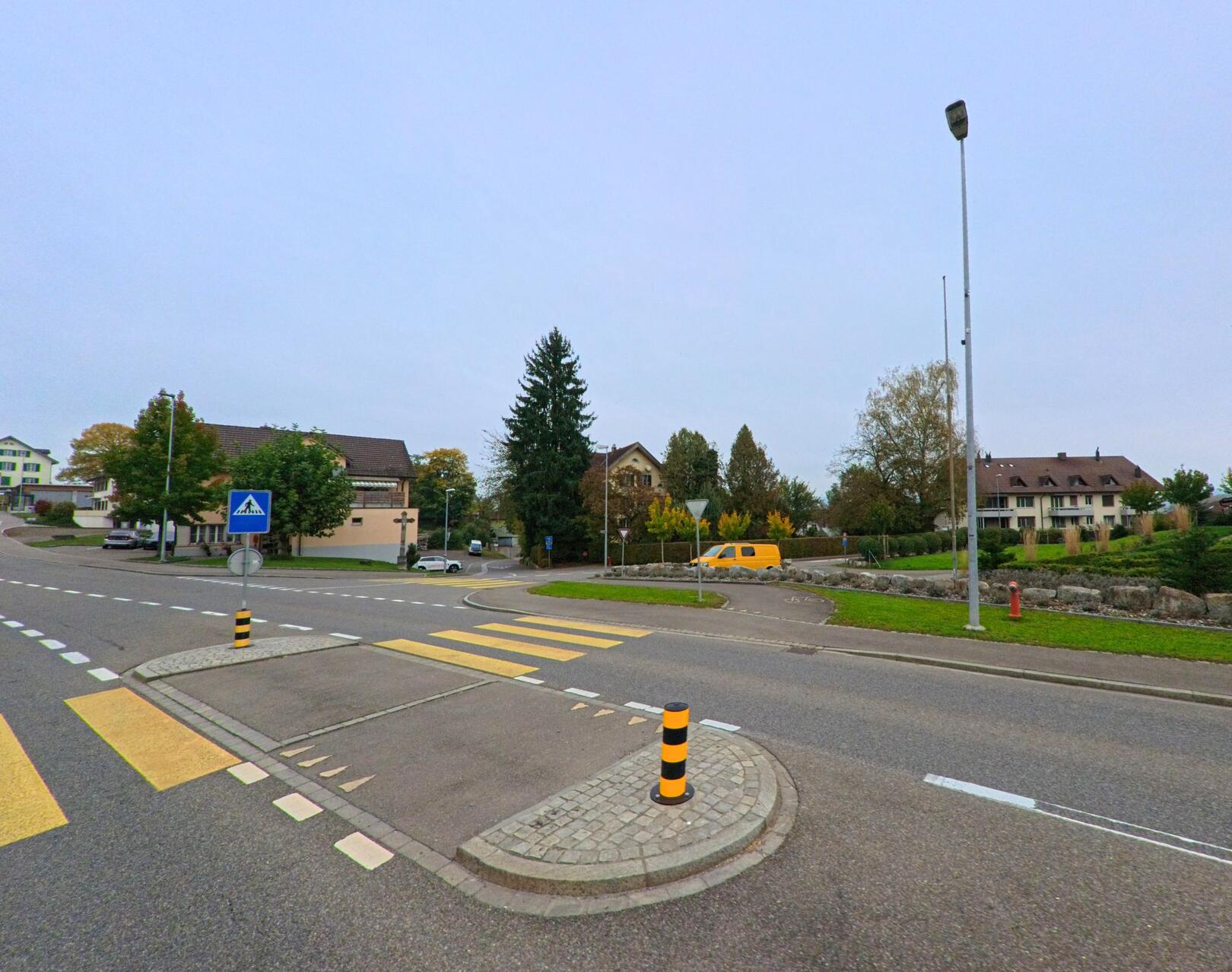 In Aristau (5628, Kanton Aargau) kreuzen sich mehrere Strassen mit Fussgaengerstreifen und Verkehrsinseln im Zentrum des Dorfes.