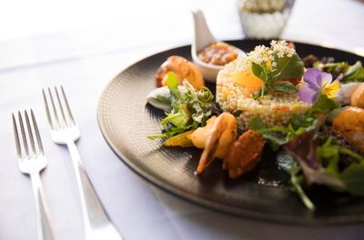 Auf einem Tisch in Genolier (1272, Kanton Waadt) steht ein kunstvoll angerichtetes Gericht mit Garnelen, Couscous und essbaren Blüten.