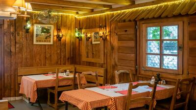 In Geneve (1201, Kanton Genf) zeigt die Auberge de Saviese ein gemuetliches Gastraum-Interieur mit Holzwaenden, karierten Tischdecken und warmer Beleuchtung.