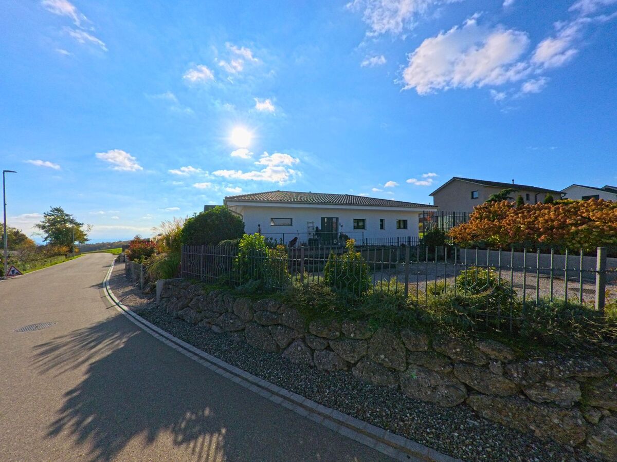 Ein modernes Wohnhaus mit klaren Linien steht an einer leicht ansteigenden Strasse in Büttenhardt (8236, Kanton Schaffhausen).