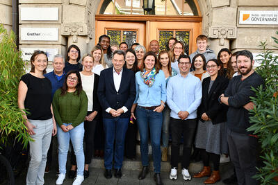 Eine gemischte Gruppe von Mitarbeitenden steht vor einem historischen Gebaeudeeingang in Basel (4051, Kanton Basel-Stadt) und posiert gemeinsam fuer ein Gruppenfoto.