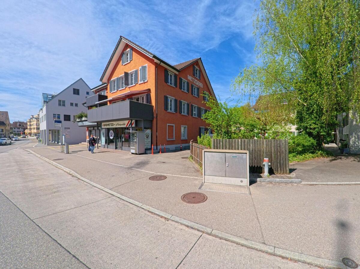 Ein auffällig orangefarbenes Gebäude in Bassersdorf (8303, Kanton Zürich) beherbergt eine Metzgerei mit moderner Ladenfront, direkt an der Strasse in zentraler Lage.