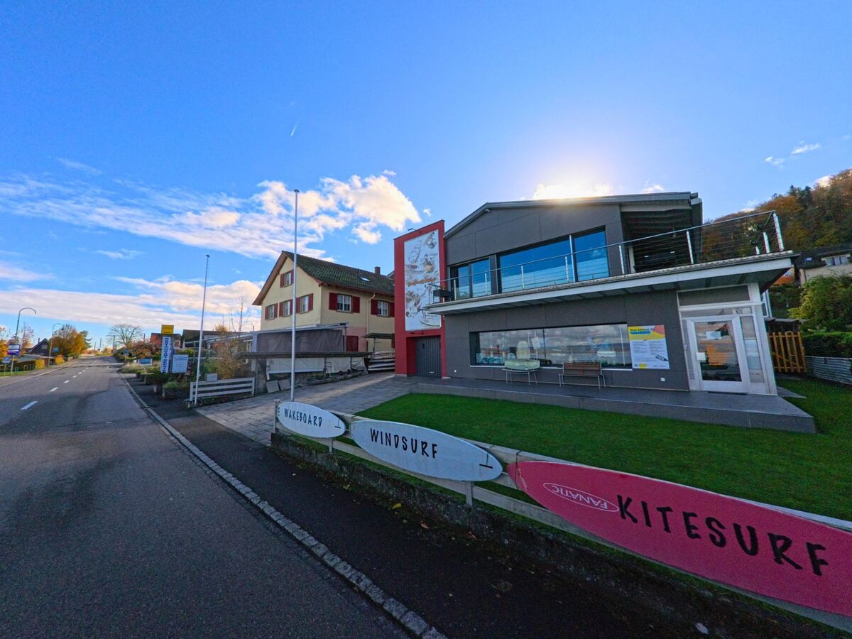 An der Hauptstrasse von Berlingen (8267, Kanton Thurgau) steht ein modernes Geschäftsgebäude mit grossen Fensterfronten und gepflegter Grünfläche unter hellem Himmel.