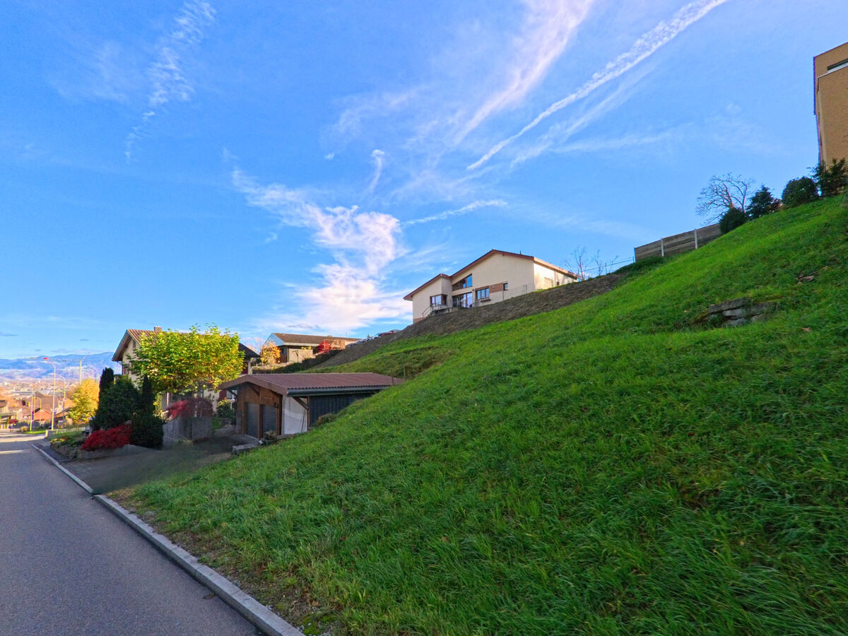 Am Hang verlaeuft eine schmale Strasse oberhalb von Wohnbauten in Berneck (9442, Kanton St. Gallen).