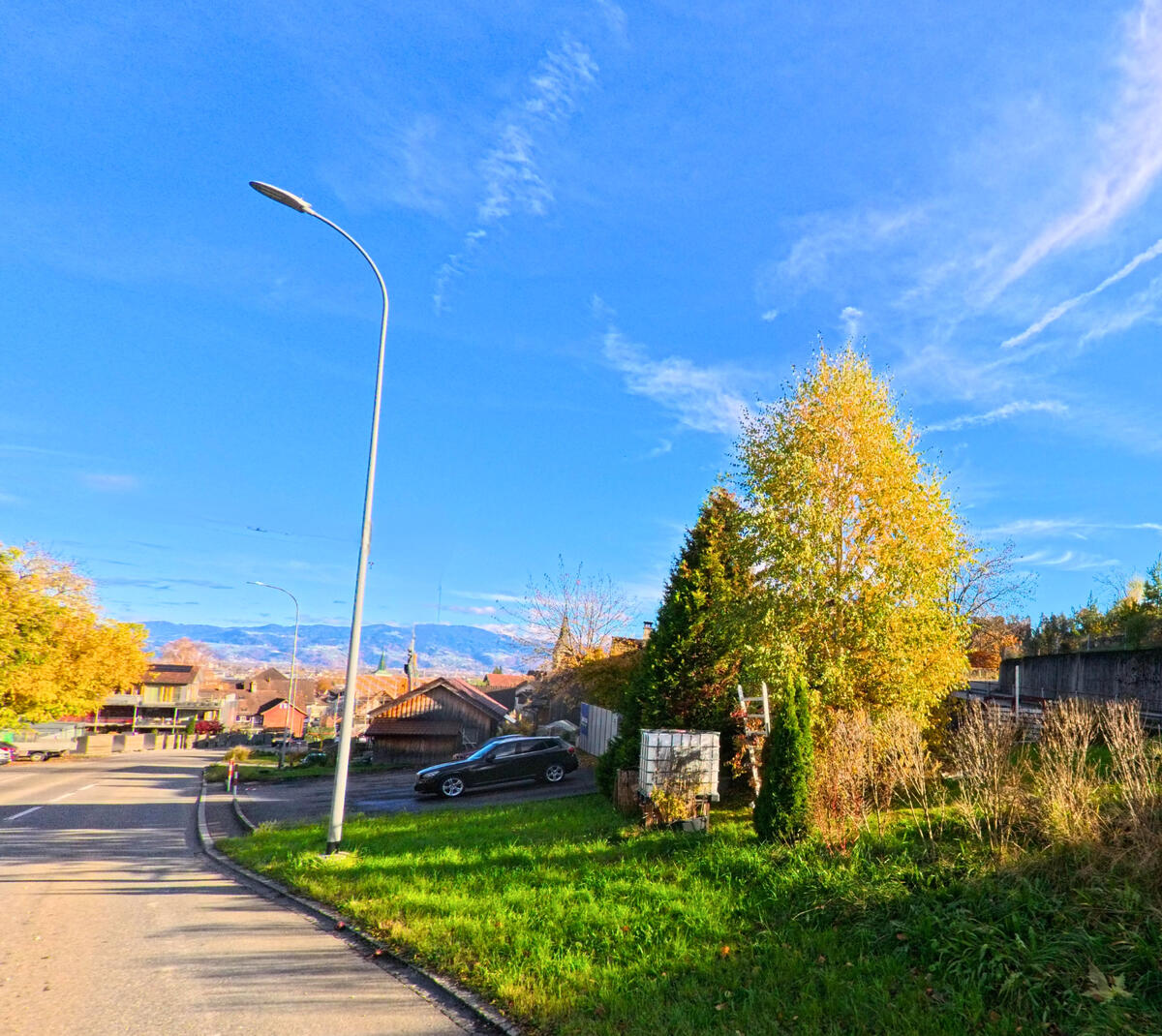 Eine Strassenszene mit Gruenflaechen und Gehweg zeigt den Siedlungsrand von Berneck (9442, Kanton St. Gallen).