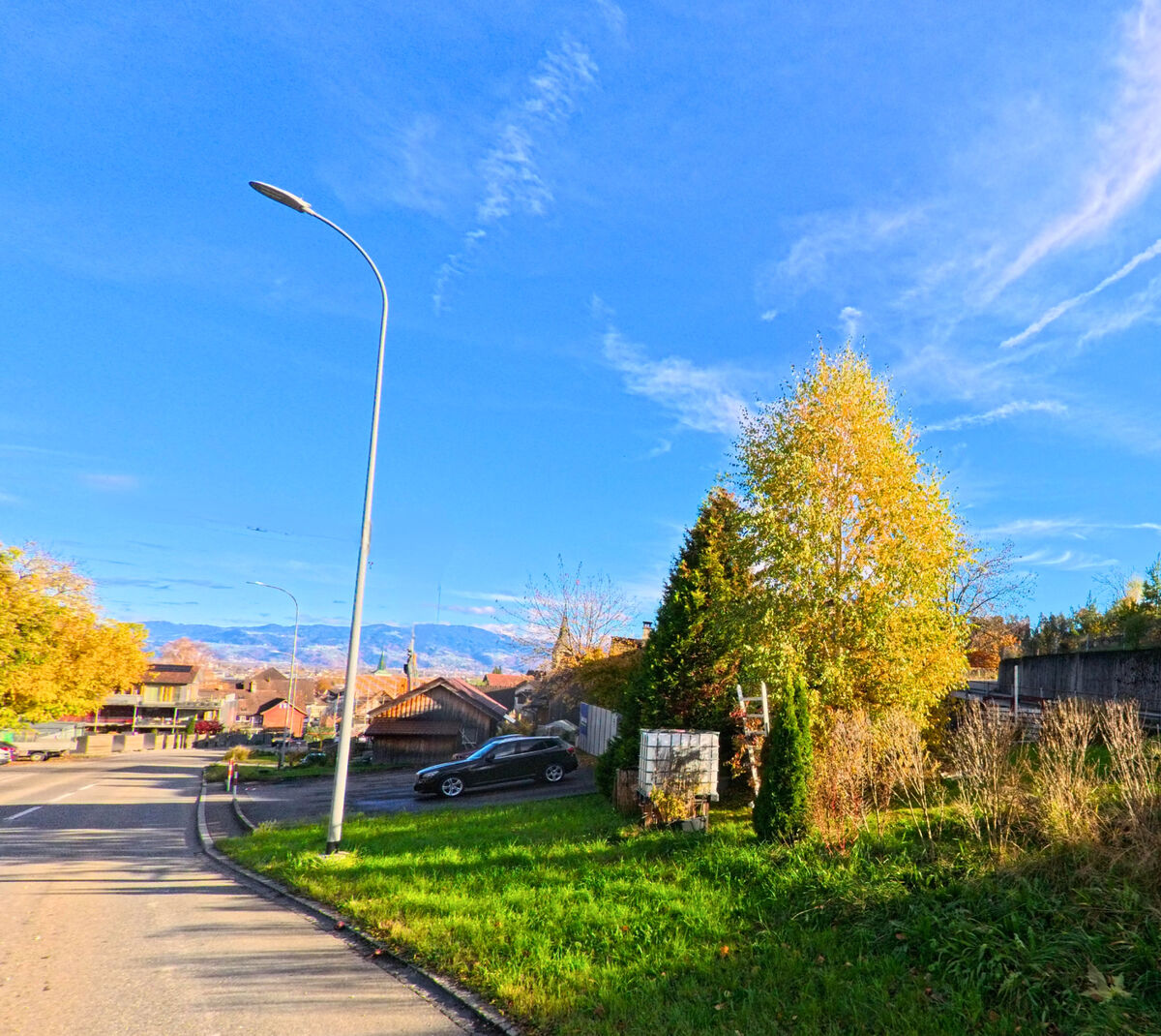 Eine Strassenszene mit Gruenflaechen und Gehweg zeigt den Siedlungsrand von Berneck (9442, Kanton St. Gallen).