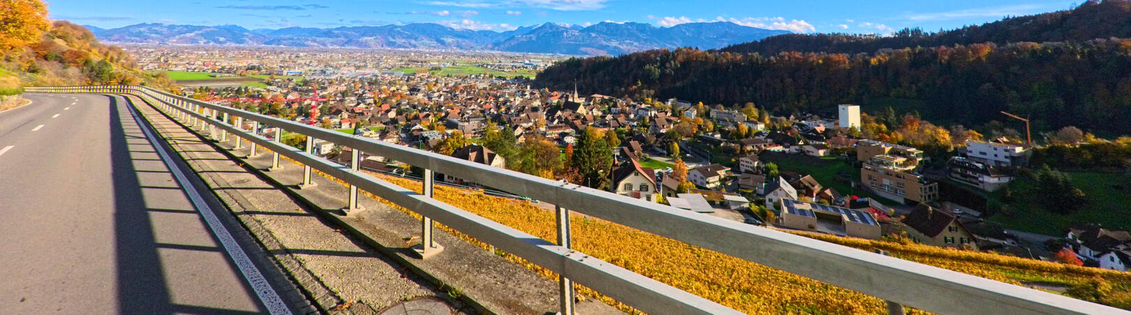 Von der Strasse oberhalb von Berneck (9442, Kanton St. Gallen) bietet sich ein weitläufiger Blick auf das Dorf, umgeben von grünen Feldern und sanften Hügeln.