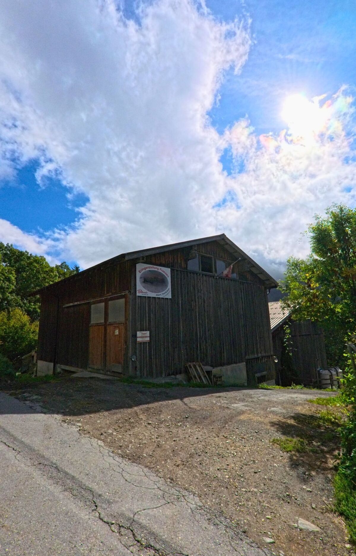 Ein Holzstadel mit Schildern und einfacher Fassade steht am Rand einer Strasse in Bettmeralp (3991, Kanton Wallis).