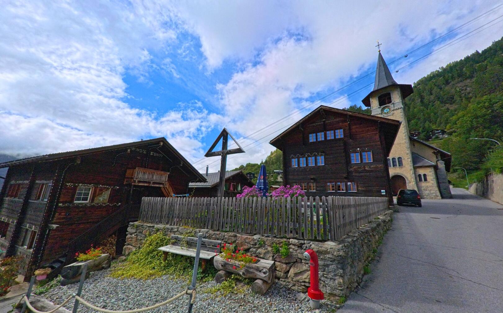 Die Kirche mit ihrem markanten Turm und angrenzenden Holzhäusern prägt das Dorfbild von Bettmeralp (3991, Kanton Wallis).
