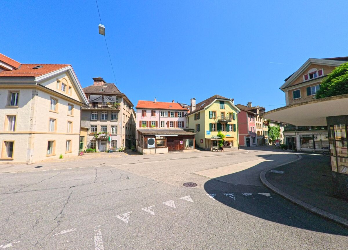 Der malerische Platz in Biel/Bienne (2500, Kanton Bern) ist von bunten historischen Gebäuden umgeben, mit einer klaren Strasse und wolkenlosem Himmel.