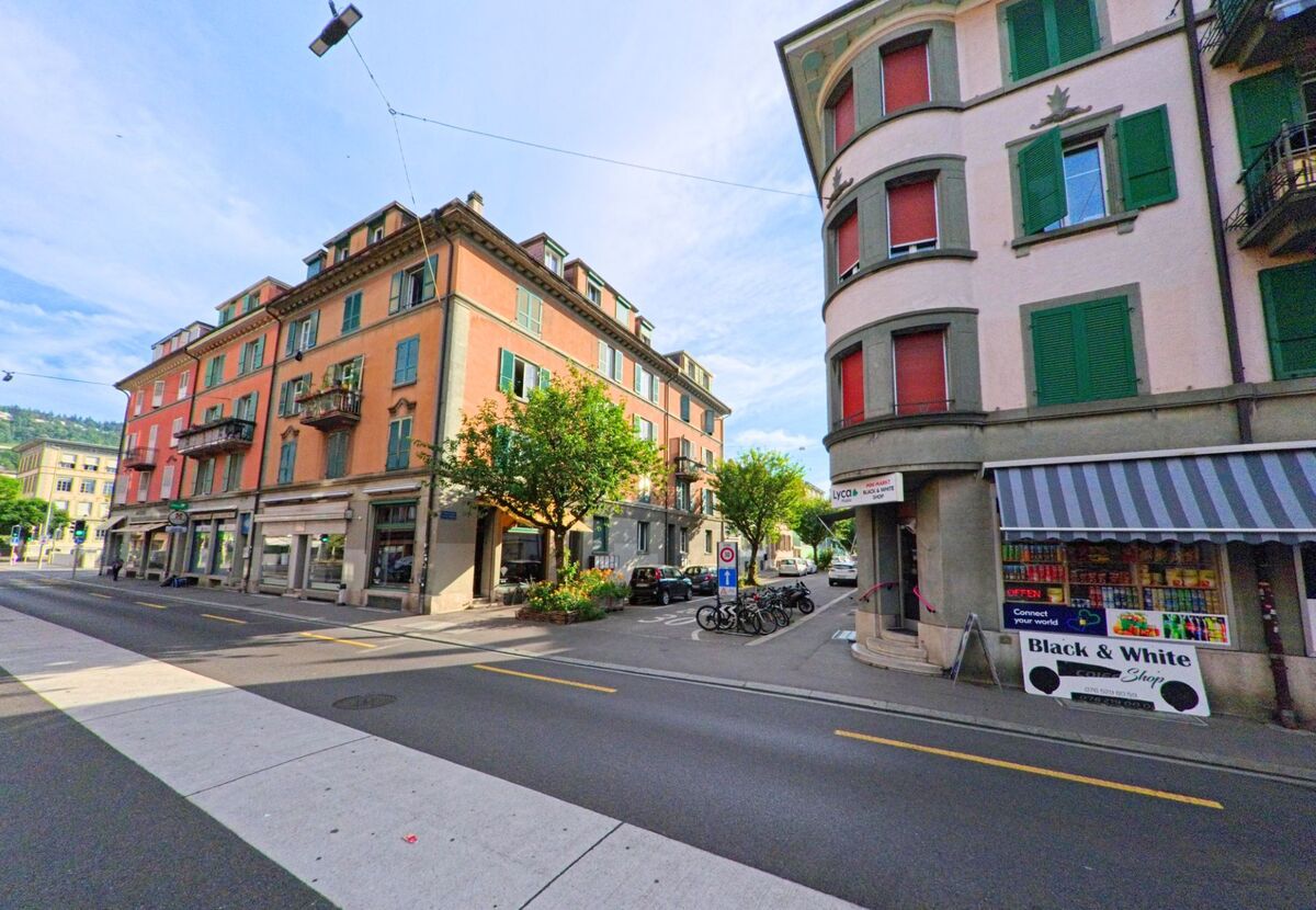 In Biel/Bienne (2500, Kanton Bern) wird die Strassenszene von farbenfrohen Gebäuden und einem kleinen Laden geprägt, während die Strassenbeleuchtung und Fahrräder den urbanen Charakter betonen.