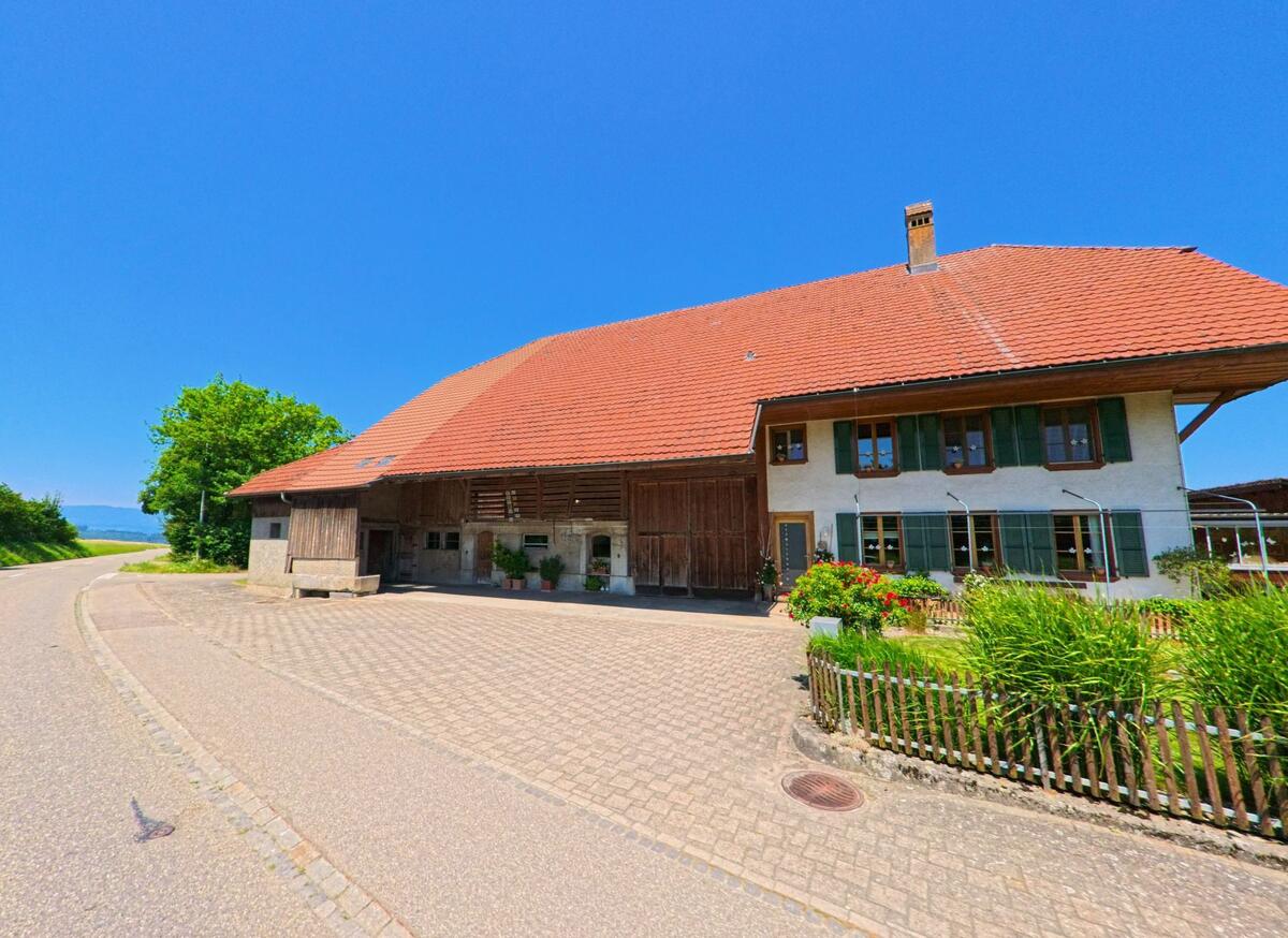 Am südlichen Dorfrand von Biezwil (4585, Kanton Solothurn) steht ein grosser Bauernhof mit Ziegeldach, angrenzendem Garten und Blick auf die Landschaft.