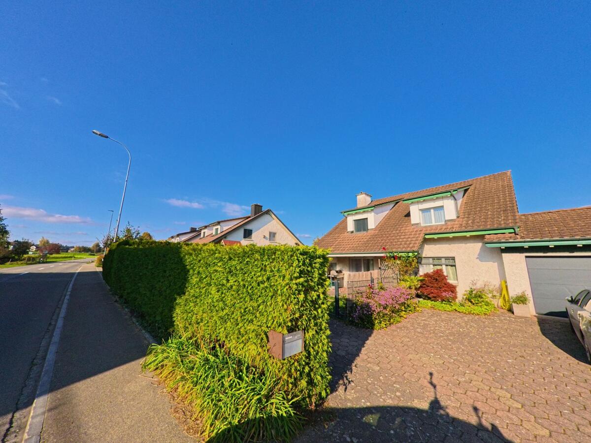 Hinter einer dichten Hecke und einem gepflasterten Vorplatz liegt in Birwinken (8585, Kanton Thurgau) ein Einfamilienhaus an einer ruhig verlaufenden Dorfstrasse.