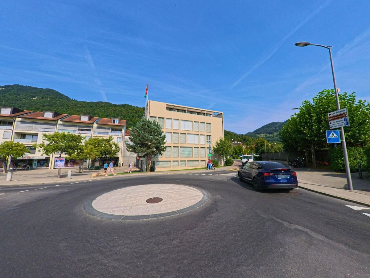 Ein moderner Verwaltungsbau mit grosser Fensterfront steht in Blonay_-_Saint-Legier (1807, Kanton Waadt) an einem kleinen Kreisverkehr.