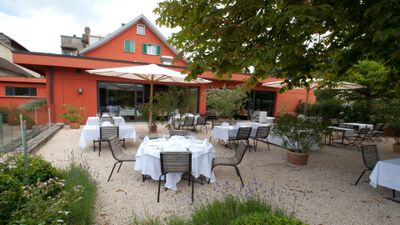 In Lichtensteig (9620, Kanton St. Gallen) bietet die Bodega Noi eine gepflegte Gartenterrasse mit weiss gedeckten Tischen unter Sonnenschirmen.