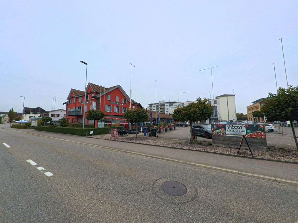 In Böttstein (5314, Kanton Aargau) steht an der Hauptstrasse ein rotes Gebäude mit Restaurant und Bar, daneben befindet sich eine Terrasse mit Sitzplätzen und ein Schild für Pizza und Grill.