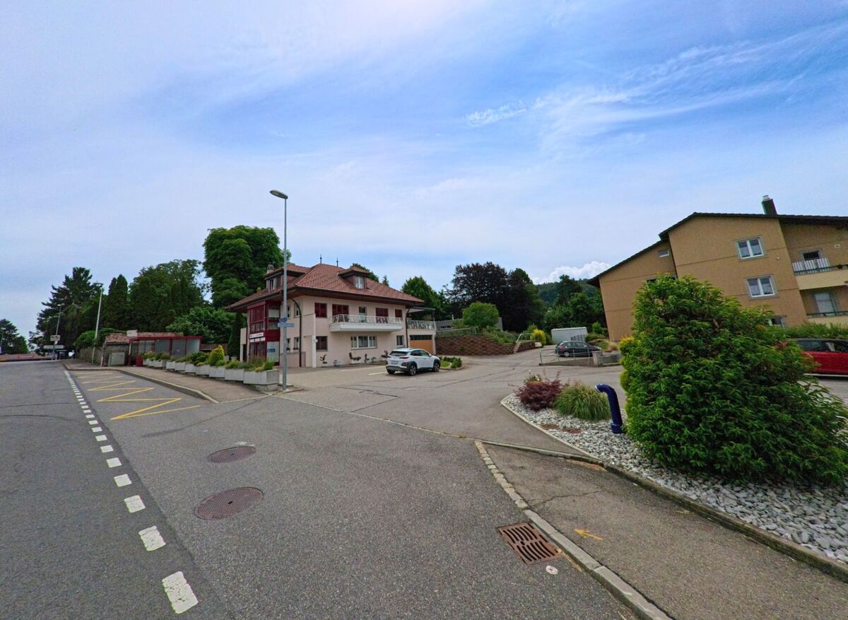 In Bois-d’Amont (1731, Kanton Freiburg) liegt ein kleines Wohnquartier mit mehrstöckigen Häusern, gepflegten Vorplätzen und markierten Parkzonen.