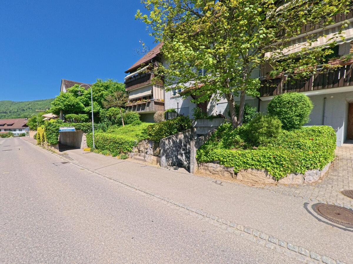 An der Rebhaldenstrasse in Boppelsen im PLZ-Gebiet 8113 im Kanton Zürich stehen gepflegte Mehrfamilienhäuser mit begrünten Vorgärten und blühenden Balkonen