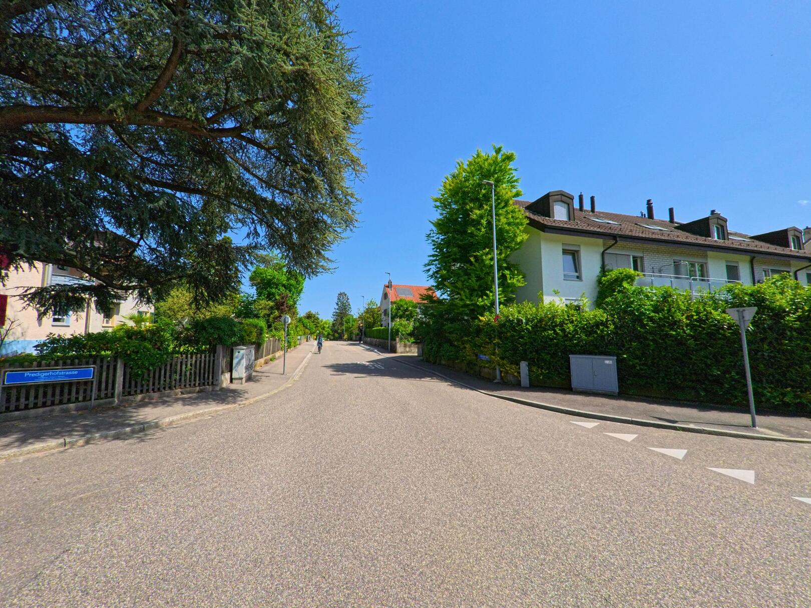 In Bottmingen (4103, Kanton Basel-Landschaft) zweigt die Predigerhofstrasse von einer ruhigen Wohnstrasse ab, gesäumt von Einfamilienhäusern und gepflegten Vorgärten.