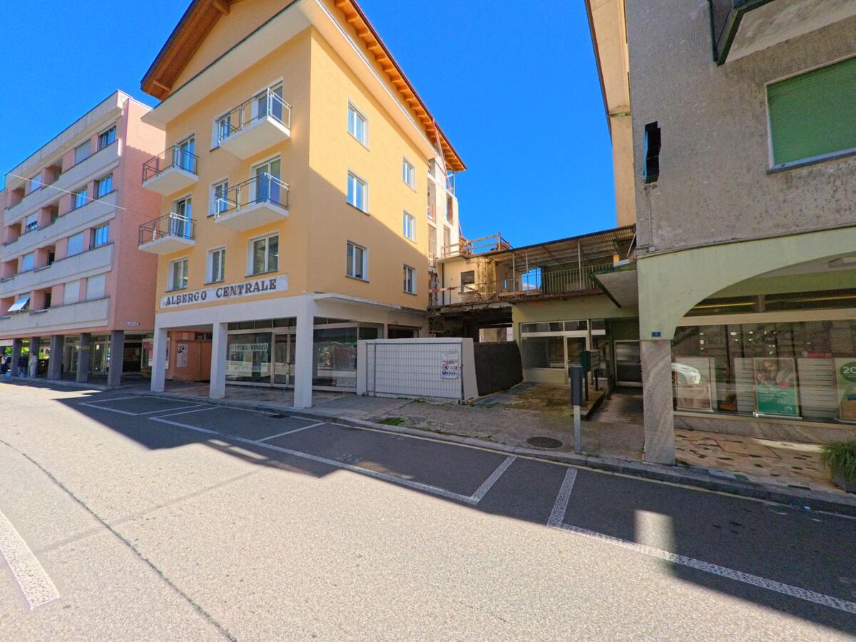 In Brissago (6614, Kanton Tessin) steht das gelbe Gebäude des Albergo Centrale an einer ruhigen Strasse mit Wohn- und Geschäftshäusern.