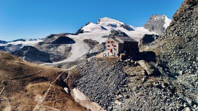 Die Britannia Hütte SAC in Saas-Grund (3910, Kanton Wallis) liegt auf einem Felsplateau mit Blick auf Gletscher und schneebedeckte Gipfel der Walliser Alpen.