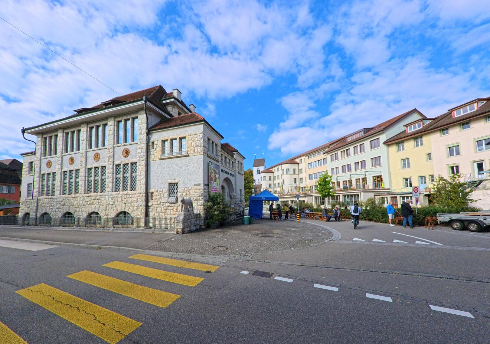 Das Vindonissa-Museum in Brugg (5222, Kanton Aargau) steht an einer gepflasterten Strasse mit Fussgängerstreifen und angrenzenden Wohnhäusern.