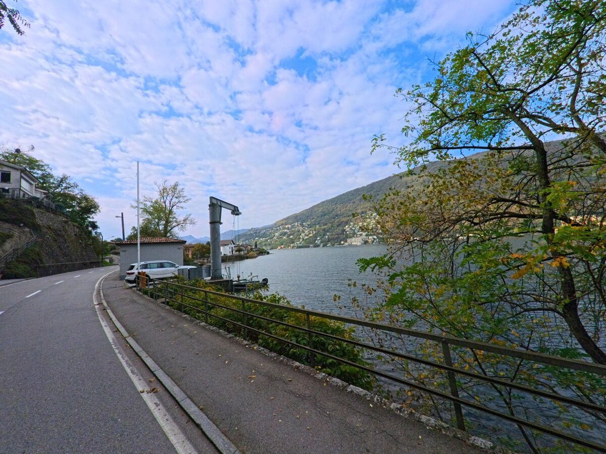 Die Uferstrasse in Brusino Arsizio (6827, Kanton Tessin) verläuft direkt am Luganersee und bietet einen weiten Blick auf das gegenüberliegende Seeufer.