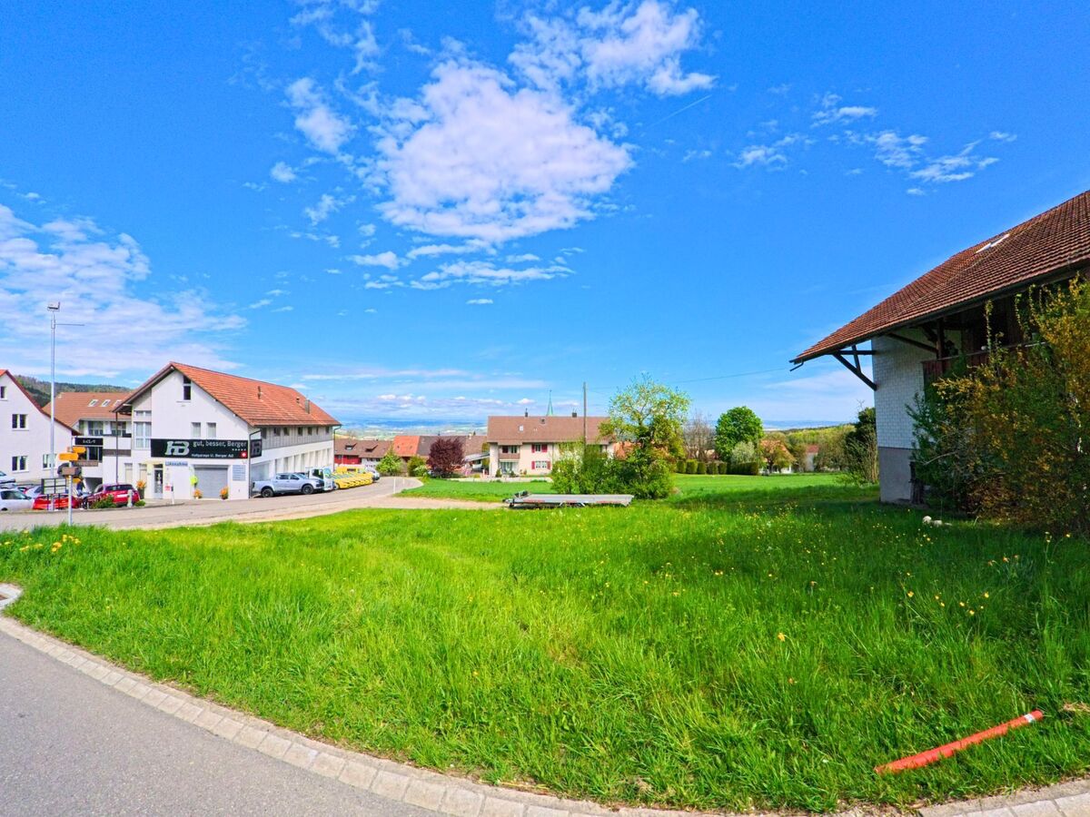 In Buch am Irchel, 8414 im Kanton Zürich liegt ein kleines Gewerbegebäude mit angrenzender Grünfläche in einer locker bebauten Siedlung mit Blick auf die umliegende Landschaft.