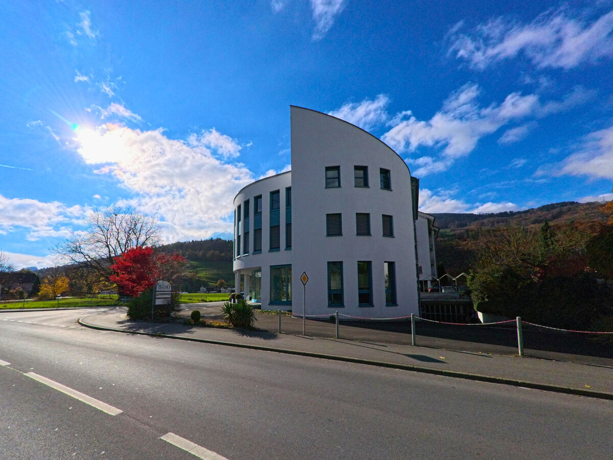 Ein modernes, rundes Gebaeude mit heller Fassade befindet sich an einer Strasse in Buchs (9470, Kanton St. Gallen).