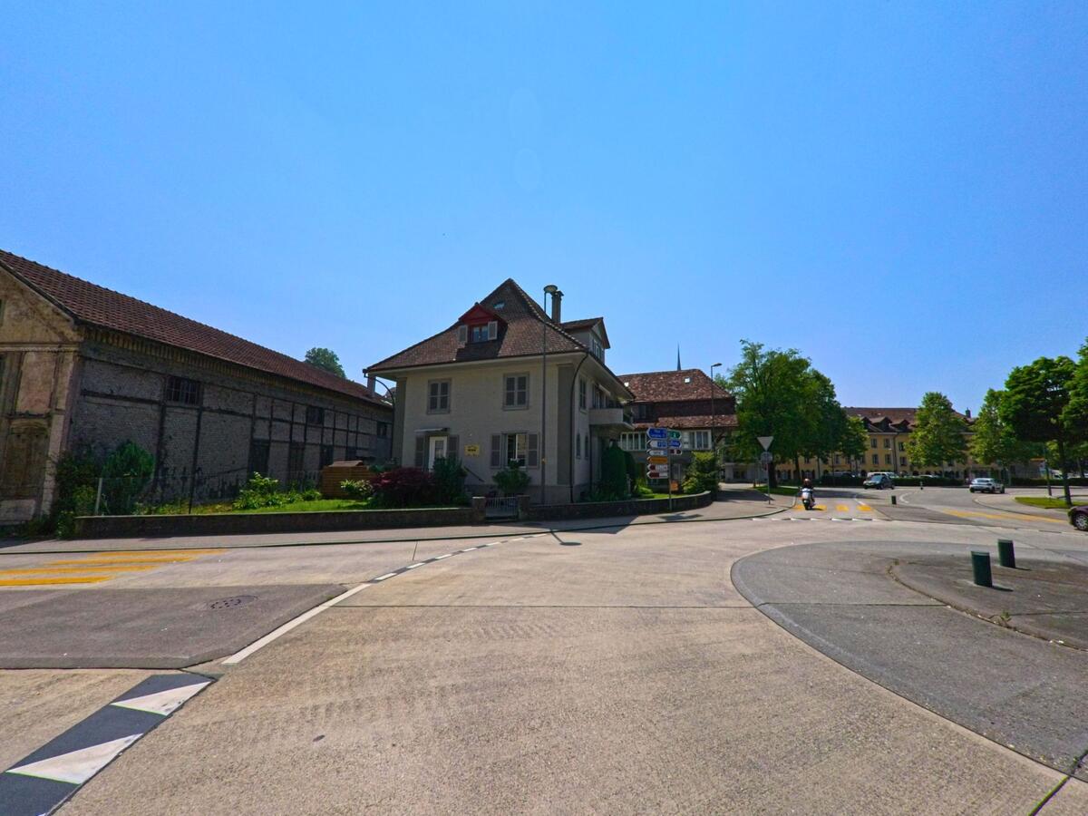 In Burgdorf (3400, Kanton Bern) liegt ein kleines Wohnhaus an einer Strassenverzweigung, umgeben von historischen Gebäuden und einem alten Bauernhaus.