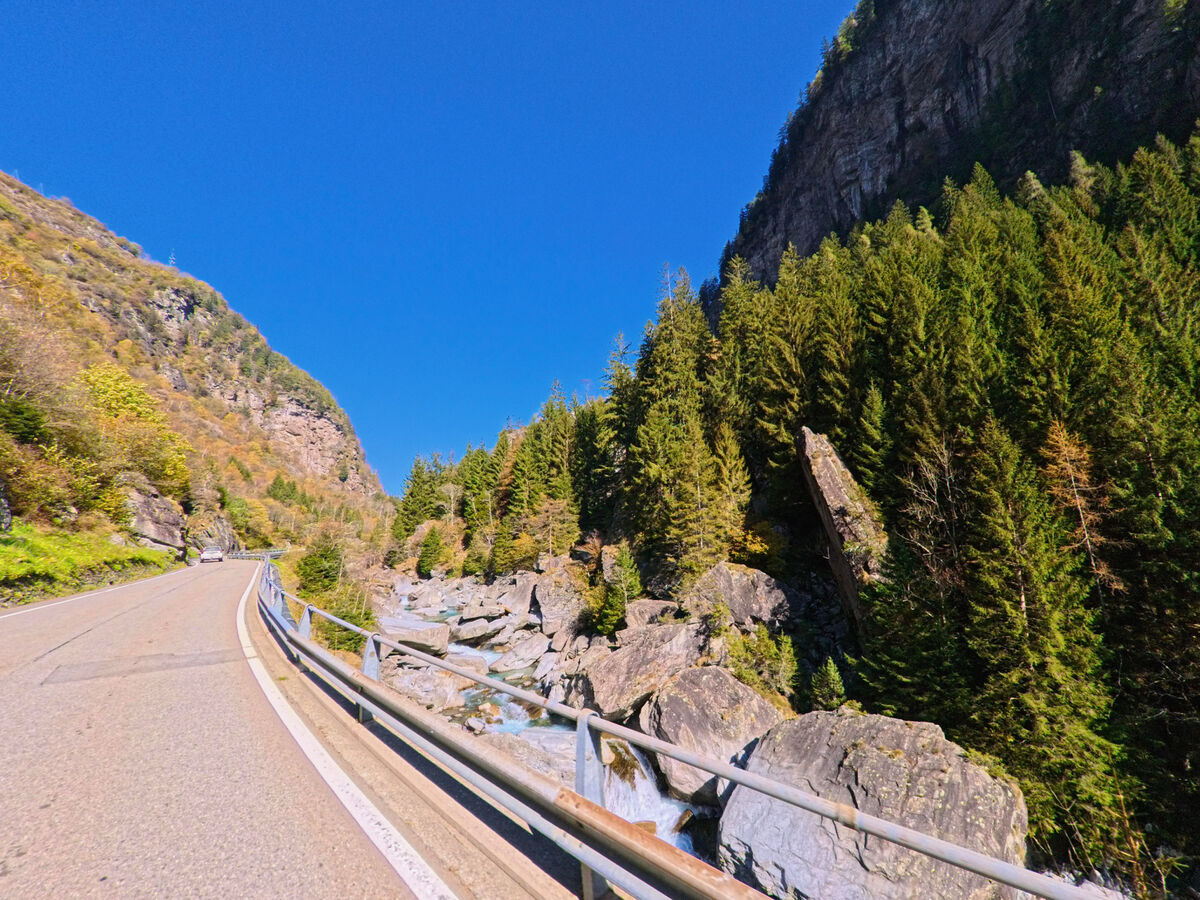 Die Bergstrasse fuehrt durch felsiges Gelaende bei Calanca im Kanton Graubünden, PLZ 6545, begleitet von Leitplanken.