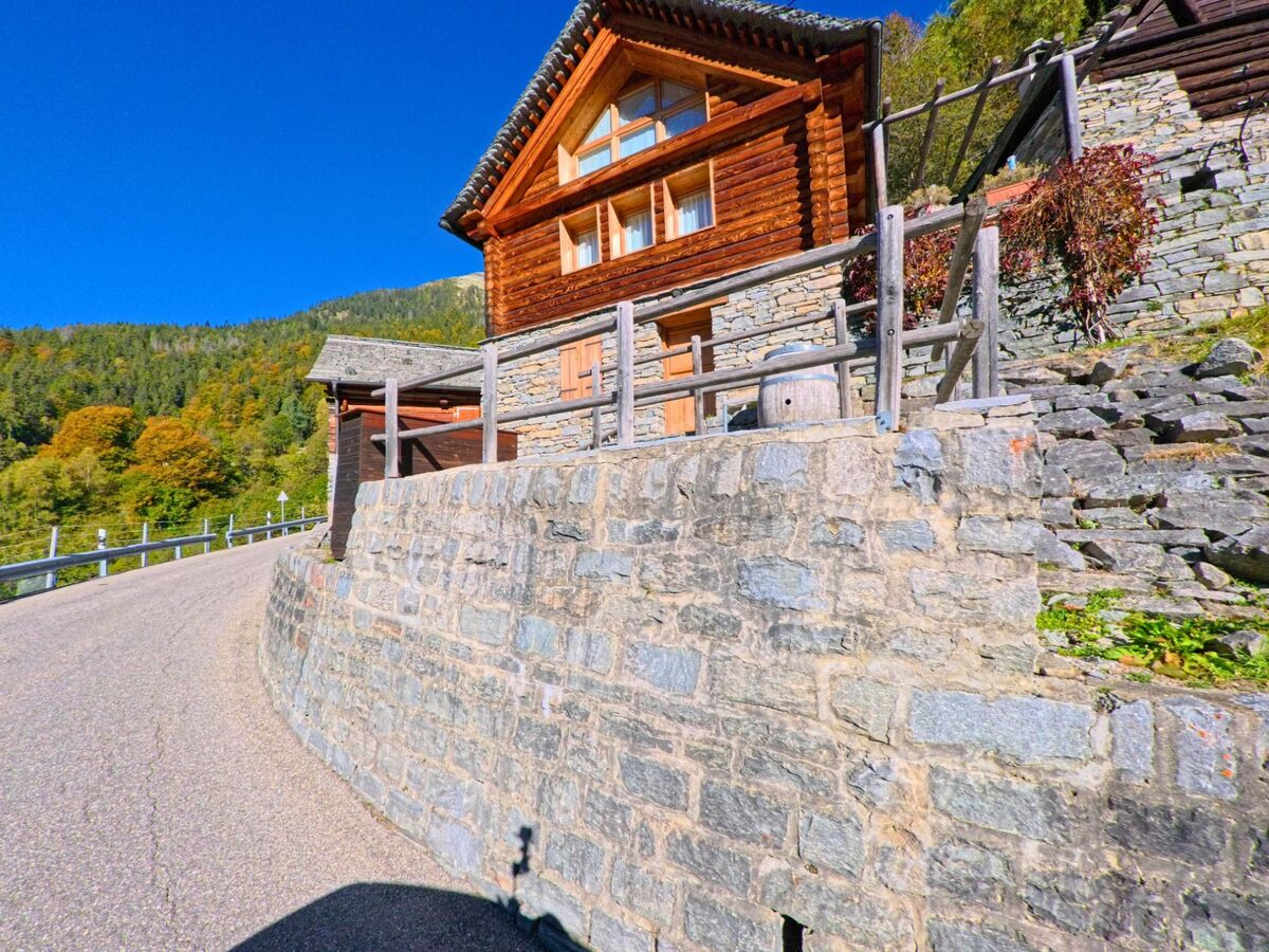 Terrassenförmig angelegte Steinmauern mit einer kleinen Sitzbank und Blumentöpfen schmücken in Campo (6684, Kanton Tessin) den unteren Dorfbereich unterhalb traditioneller Häuser.