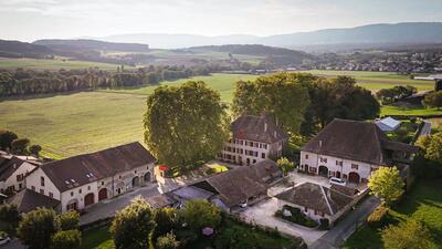 Das Château d’Eclépens in Eclépens (1312, Kanton Waadt) liegt eingebettet in eine weite, grüne Landschaft und wird von alten Bäumen umgeben.