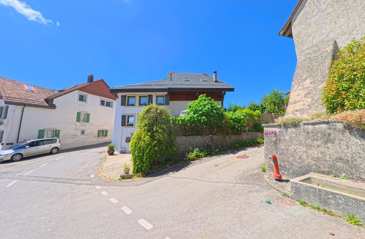 Im Zentrum von Chavannes-sur-Moudon (1512, Kanton Waadt) treffen enge Gassen aufeinander, gesäumt von gepflegten Häusern und einem historischen Brunnen.