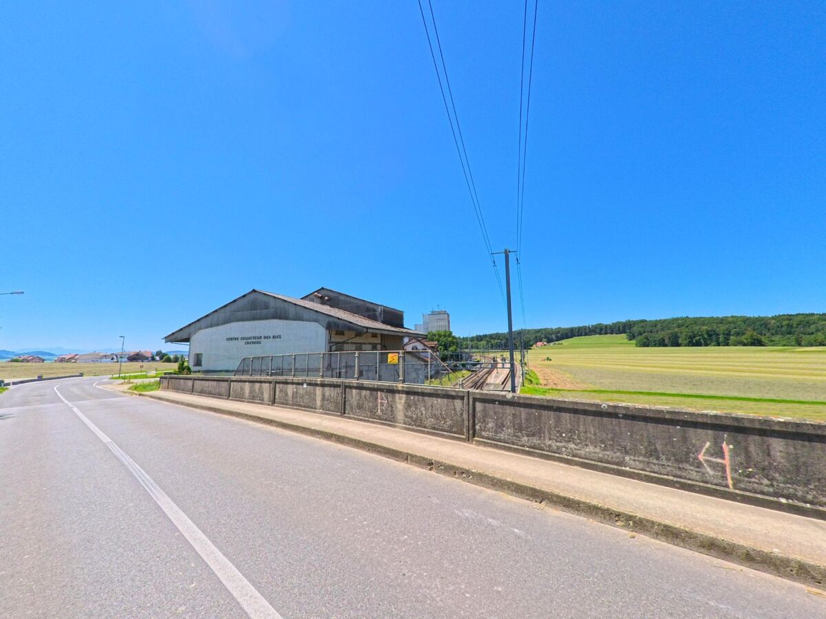 Neben den Bahngleisen am Ortsrand von Chénens (1744, Kanton Freiburg) steht ein grosses Lagergebäude mit der Aufschrift „Centre Collecteur des Bles“.