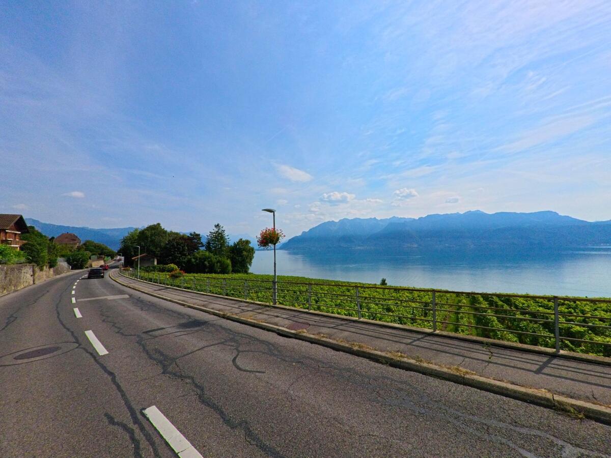 In Chexbres (1071, Kanton Waadt) verläuft eine kurvige Strasse entlang der Weinberge mit freiem Blick über den Genfersee und die gegenüberliegenden Berge.