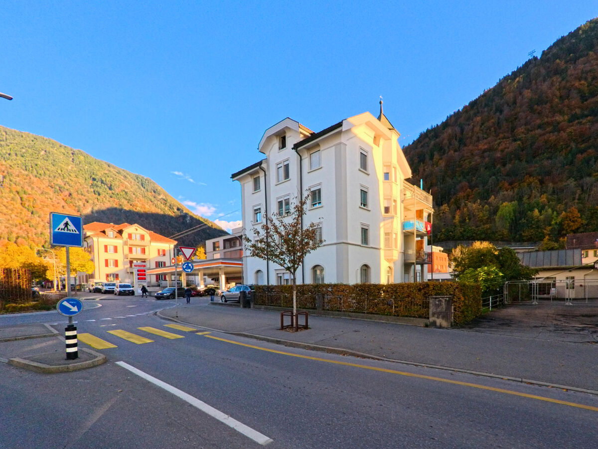 An einer Strassenkreuzung mit Fussgaengerstreifen stehen Wohn- und Geschaeftshaeuser in Chur (7000, Kanton Graubünden).